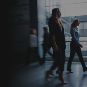 Personas caminando en un edificio moderno, simbolizando progreso y dinamismo. Formación Bitcoin con Daniel Chinesta.